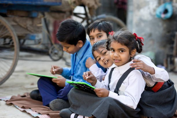 Little schoolboys and schoolgirls in uniform writing on slate